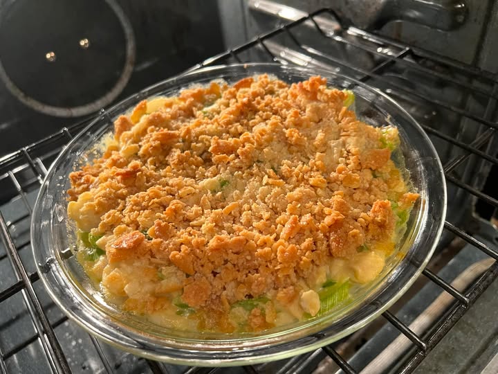 Creamy celery water chestnut casserole with buttery Ritz cracker topping baking in the oven.