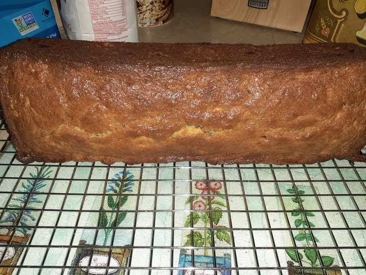 Moist and golden loaf of homemade sour cream banana bread cooling on a wire rack.